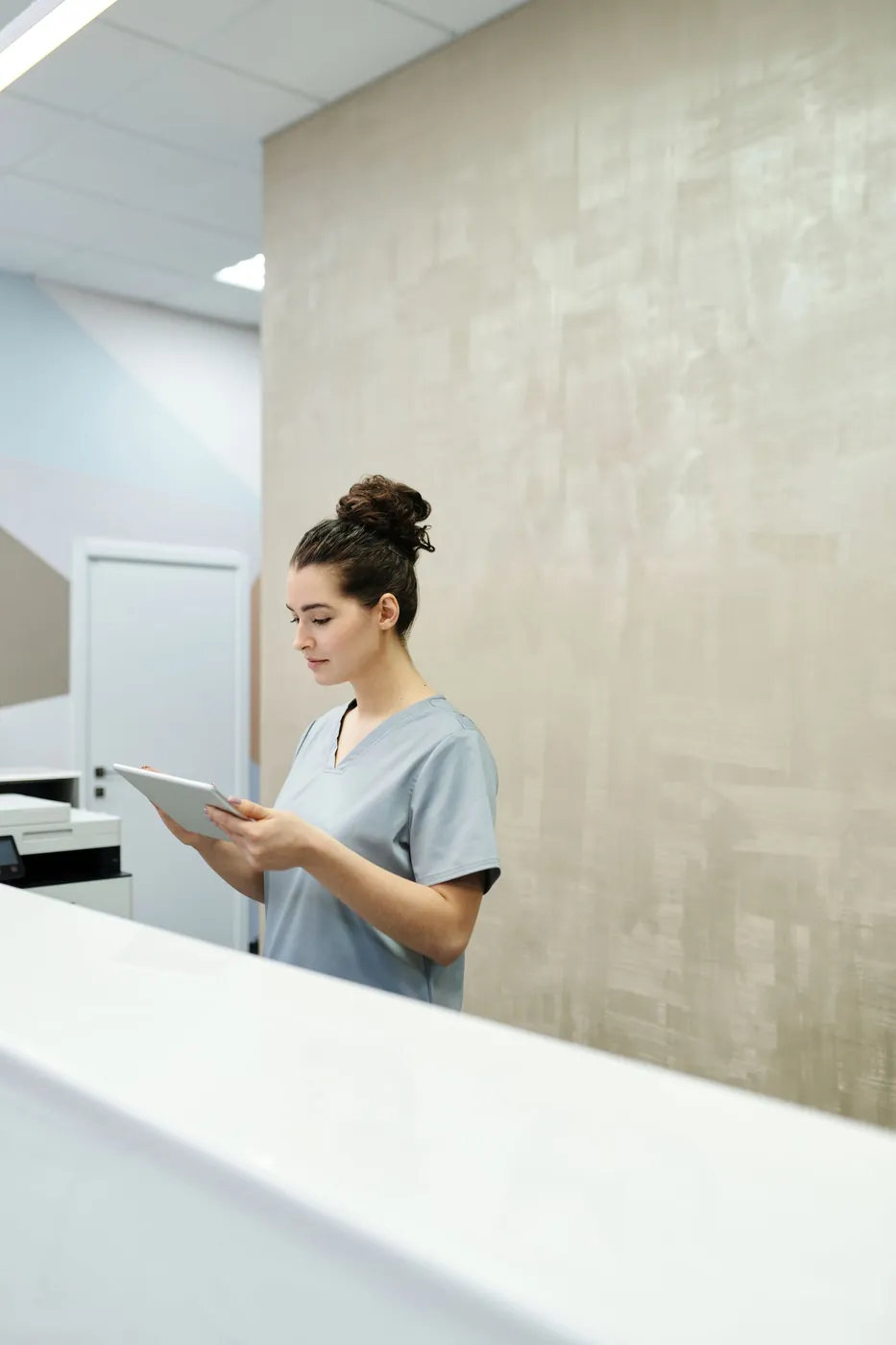 Integrante del equipo de recepción revisando una tablet en la clínica